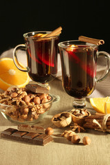 Two cups with ready mulled wine with anise, cinnamon and nuts around	