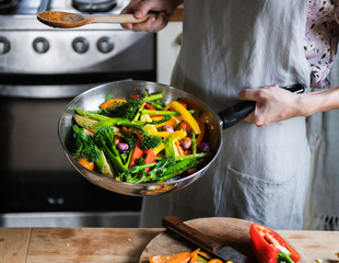 Woman cooking stir fried vegetables