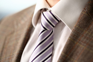 Male arm in brown suit set tie closeup