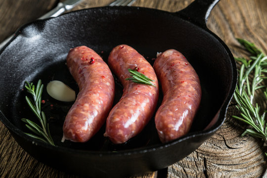 Roasting sausages in a pan with herbs and spices