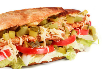 Sandwich from fresh pita bread with fillet grilled chicken, lettuce, slices of fresh tomatoes, pickles and cheese on white background