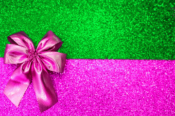 Pink bow on a color sparkling background.