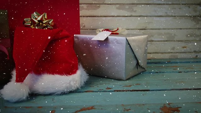Video composition with falling snow over desk with christmas decorations