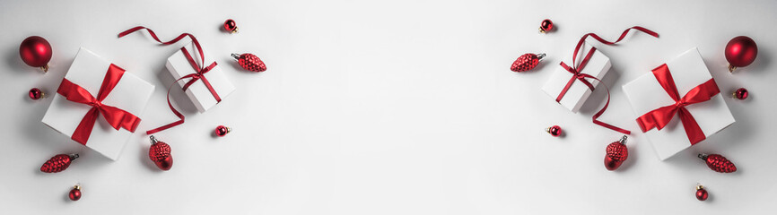 Christmas gift boxes with red ribbon and decoration on white background. Xmas and Happy New Year theme, snow. Flat lay, top view, wide composition