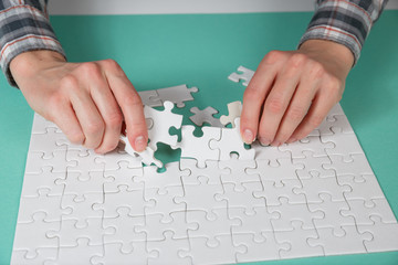 Hand put the last piece of jigsaw puzzle to complete the mission