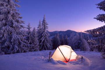 Tourist tent in winter forest at the night