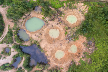 Holes on ground from powerful explosions. Bomb craters in the forest. Disposal of explosives. Top...