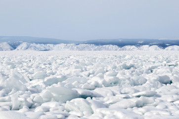 Fototapeta na wymiar Strait Small Sea of Lake Baikal in winter. Ice crackes and splinters under snow