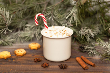 Winter hot Christmas chocolate or cocoa with marshmallow with decorations. A cup of hot chocolate with marshmallows and gingerbread on a Christmas table.