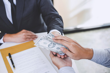 Bribery and corruption concept, bribe in the form of dollar bills, Businessman giving money while...