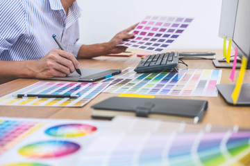 Image of male creative graphic designer working on color selection and drawing on graphics tablet...