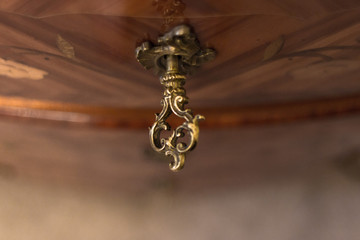 Antique key with monograms. Close the drawer, dresser, bedside tables. Keeping things in a safe place. Vintage furniture and accessories. Baroque interior.