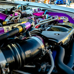 Engine components under the open hood of a car