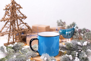 Obraz na płótnie Canvas Blue mug with hot tea with milk, coffee or cocoa on winter holidays background.