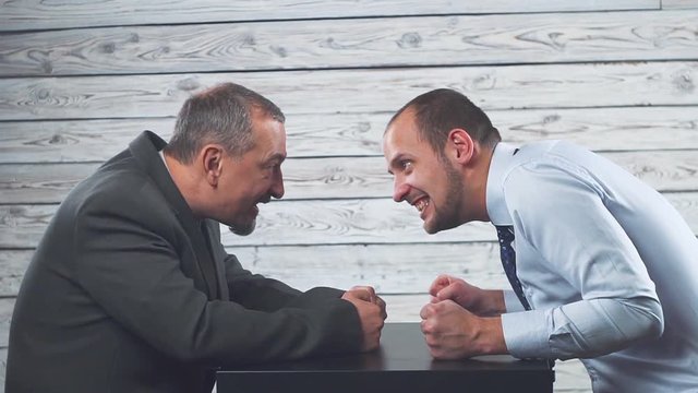 Business anger conflict. Two businessmen fiercely look at each other. Fight and strangle each other.