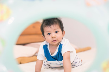 happy small baby child lying on the bedroom and smiling