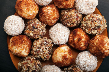 Useful fitness sweets from dried fruits, nuts and seeds, without sugar on a plate. Macro shooting. Vegan, vegan concept