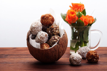Useful fitness sweets from dried fruits, nuts and seeds, without sugar in the shell of coconut on a...
