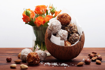 Useful fitness sweets from dried fruits, nuts and seeds, without sugar in the shell of coconut on a...