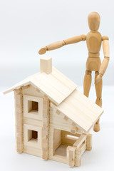 Wooden man (dummy) demonstrates house from wood