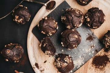 Top view of chocolate muffins on wooden board and dark background. Food styling