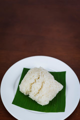 Sticky rice on banana leaf and wooden background