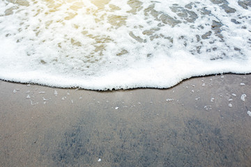 Wave of the sea on the sand beach with sunlight , for background