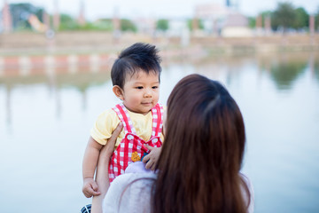 Young mother with her little son in summer park
