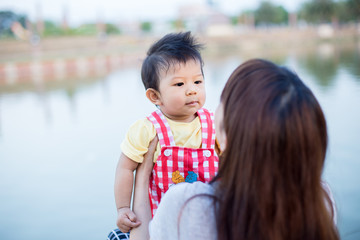 Beautiful Mother And Baby outdoors. Nature. Beauty Mum and her Child playing in Park together.