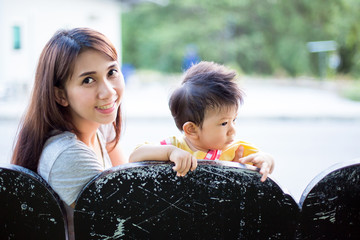 Beautiful Mother And Baby outdoors. Nature. Beauty Mum and her Child playing in Park together.