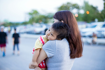 Young mother with her little son in summer park