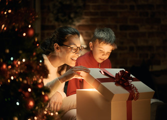 Boy and his mother opening Christmas gifts