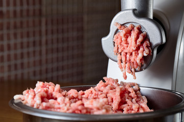 Minced meat coming out from modern electric grinder. Healthy fresh homemade minced meat. Place for...
