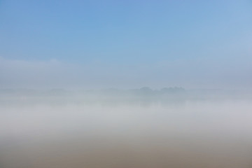 The dense morning mist covers the river and overlooks some of the opposite coasts