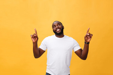 Young african american man over yellow background pointing upwards