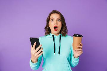 Shocked emotional young woman posing isolated over purple background wall.
