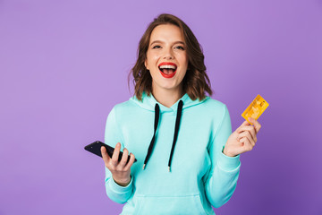 Beautiful young woman posing isolated over purple background wall.