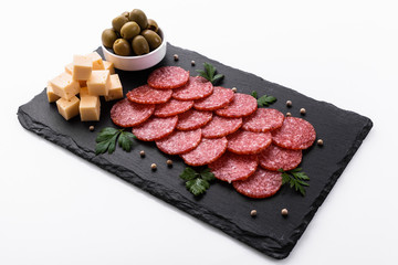 delicious sliced salami on a stone plate white background