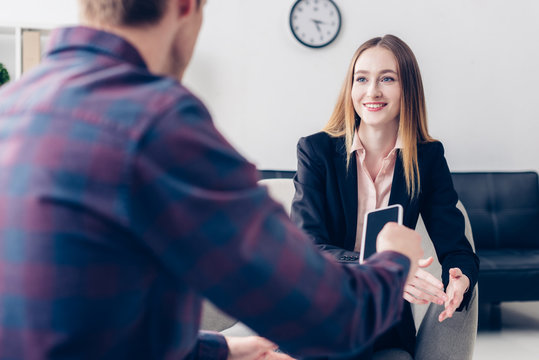 attractive businesswoman in suit giving interview to journalist in office