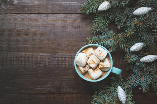 Christmas mug of hot coffee with marshmallow on wooden board. New Year. Holiday card. Rustic style. Top view and copy space.