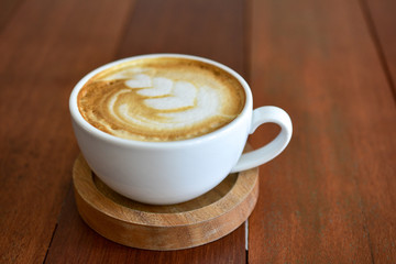 Latte art coffee on wooden table on coffee time