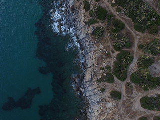 Aerial photography of the Sardinia coast during a summer sunset. Small waves on the rocks taken with a drone.