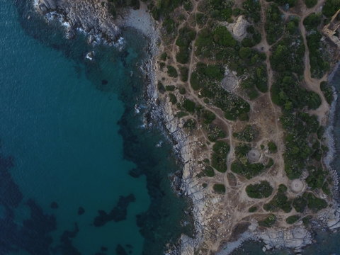 Aerial photography of the Sardinia coast during a summer sunset. Small waves on the rocks taken with a drone.