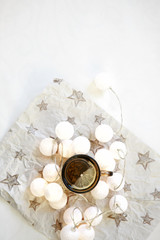  New Year's decoration. Green tea with lemon on a white background, healthy food, Christmas garland and the spirit of Christmas.