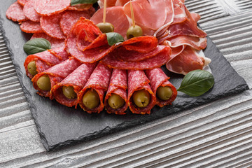 Cold smoked meat plate on a rustic wooden background
