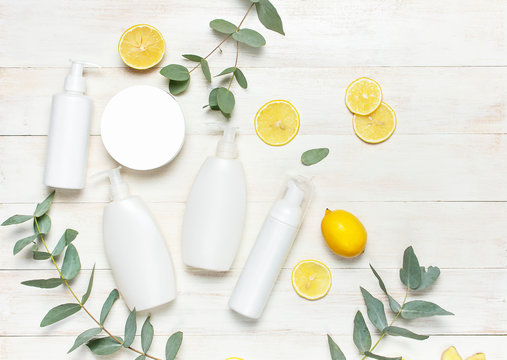 Whites Cosmetic bottle containers, fresh lemon eucalyptus on white wooden background top view flat lay copy space. Blank label for branding mock-up Natural beauty product concept Shower Gel Soap