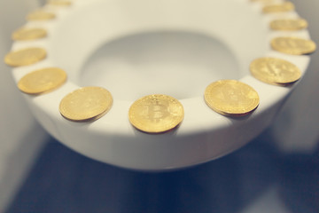 Bitcoin on the toilet. Metal Bitcoin physical currency.						