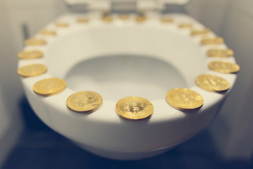 Bitcoin on the toilet. Metal Bitcoin physical currency.						