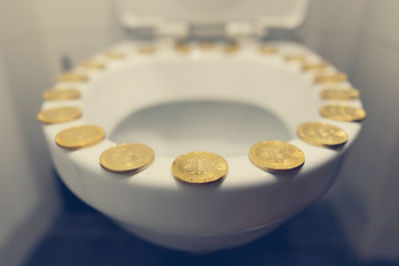 Bitcoin on the toilet. Metal Bitcoin physical currency.						