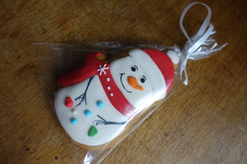 View of glazed gingerbread snowman on wooden table from above